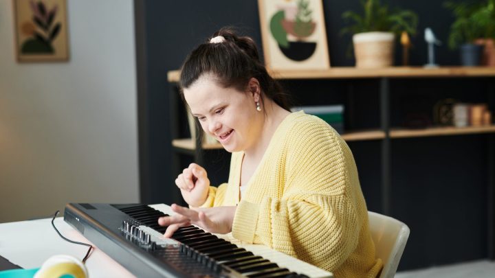 Débutant jouant du piano avec une partition posée devant lui