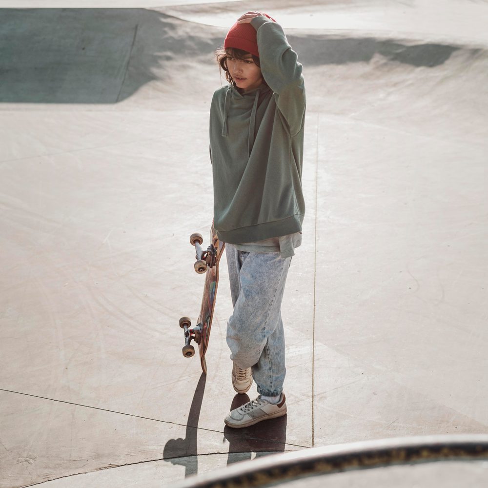 Un groupe de jeunes en vêtements streetwear se retrouve avec des skateboards en ville.