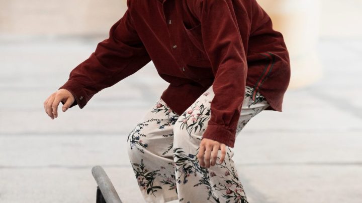 Des skateboardeurs portent des tenues streetwear décontractées dans une rue urbaine.