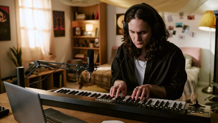 Musicien travaillant sur son ordinateur dans un home studio pour mettre sa musique sur Spotify