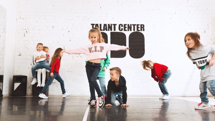 Débutants pratiquant des pas de danse hip-hop dans un studio avec un miroir