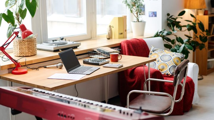Bureau de home studio débutant avec ordinateur, casque audio, clavier MIDI et enceintes de monitoring.