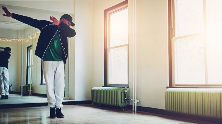 Danseuse répétant une chorégraphie devant un miroir dans un studio de danse.
