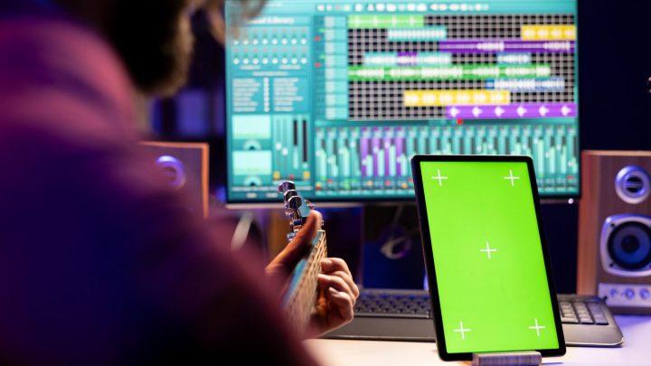 Musicien enregistrant une voix dans un home studio avec une carte son, un microphone et un casque audio.