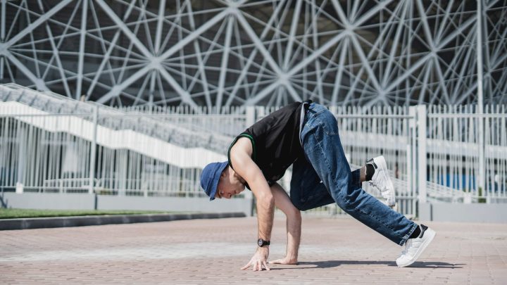 Débutant en breakdance pratiquant ses premiers mouvements au sol dans une salle d’entraînement.