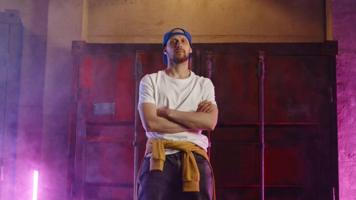Un rappeur français se produit sur scène devant un public enthousiaste.