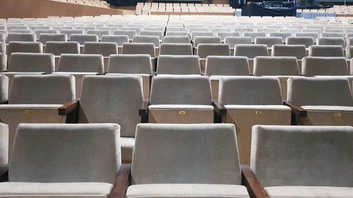 Vue d’une salle de concert depuis les gradins, avec la scène et le public visibles.