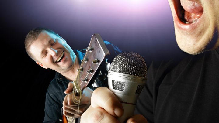 Chanteur comparant un micro dynamique et un micro statique dans un studio d’enregistrement.