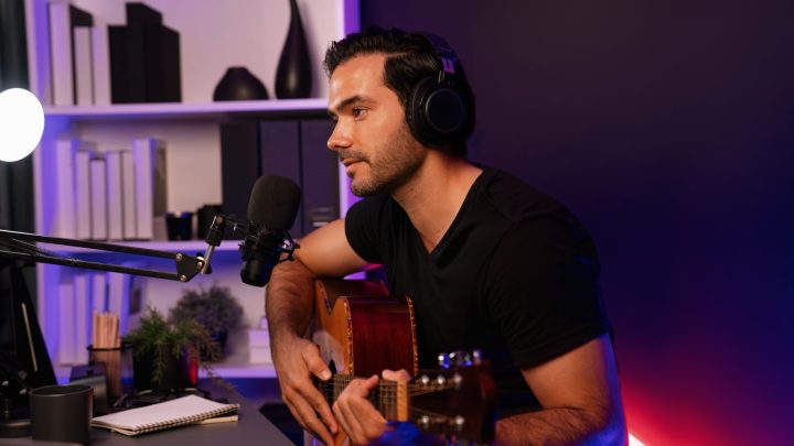 Chanteur enregistrant sa voix devant un microphone dans un home studio.