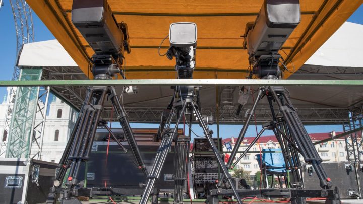 Une petite salle de concert aménagée avec une scène, des projecteurs et des rangées de chaises.