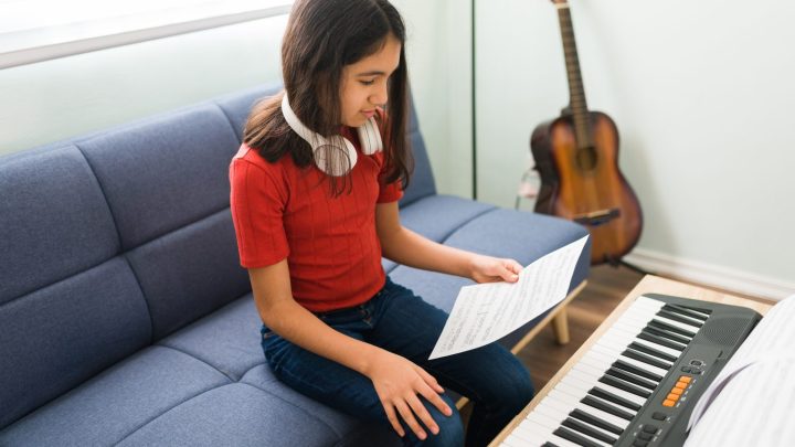 Débutant comparant un piano et une guitare pour choisir son instrument.